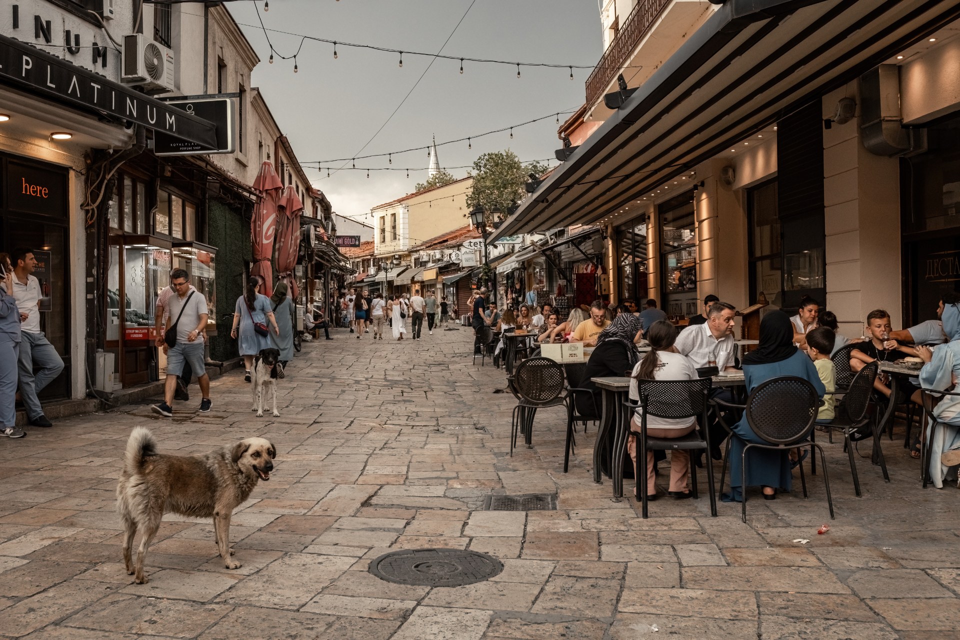 People at street cafes on a narrow market street in Skopje old town